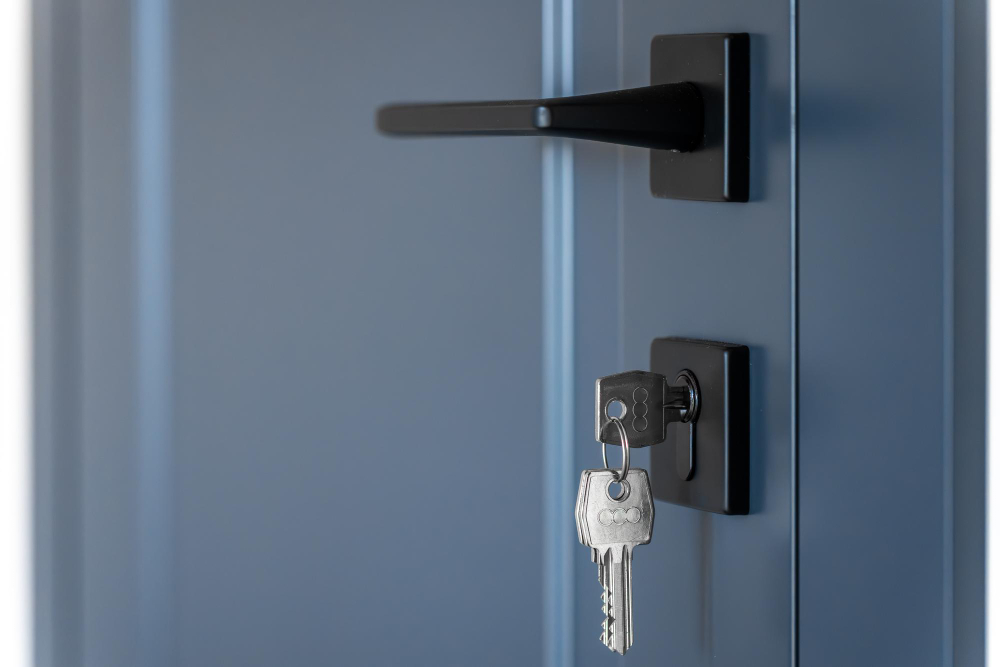 Detalhe de porta moderna com chave na fechadura, ilustrando o uso de fechadura reforçada para aumentar a segurança em entradas residenciais.